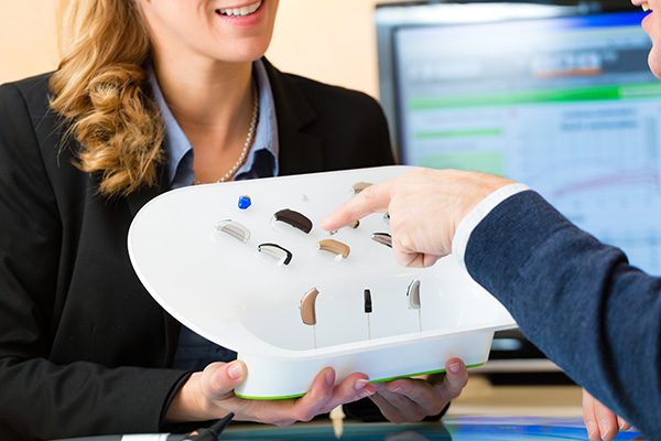 man pointing at different sets of hearing aids
